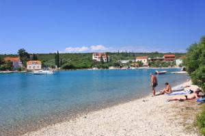 a group of people sitting on a beach near the water at Apartments by the sea Loviste, Peljesac - 262 in Lovište