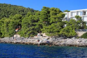 a building on the shore of a body of water at Rooms by the sea Brna, Korcula - 12614 in Smokvica