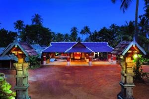 a resort with a blue roof and some palm trees at Cherai Beach Resorts in Cherai Beach