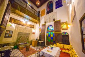 una habitación con muchas puertas de colores diferentes y una mesa en Dar Lalamoune en Fez