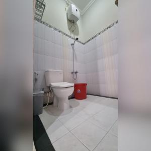 a bathroom with a toilet and a phone in it at Oemah Wisata RinginSari -Full House, 5 Bed Rooms- in Kalasan