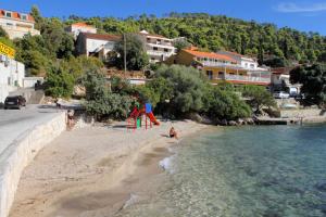 einen Sandstrand mit Spielplatz und Wasser in der Unterkunft Family friendly house with a swimming pool Brna, Korcula - 13943 in Smokvica