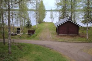 ein kleines Gebäude an der Seite einer unbefestigten Straße in der Unterkunft Pohjantilan Hirsituvat - Pohjantähti in Kontiolahti