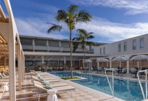 a pool at a hotel with chairs and a palm tree at InterContinental Sorrento Mornington Peninsula in Sorrento