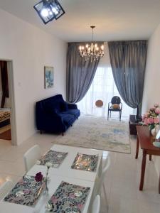 a living room with a table and a blue couch at Muslim Boutique Apartment with Balcony in Tanah Rata