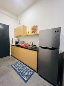 una cucina con frigorifero e piano di lavoro di EmpiStudio @ Empire Damansara a Petaling Jaya