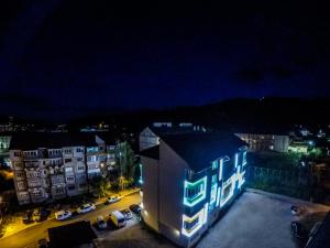 a building with lights on the side of it at night at Straja Apart in Lupeni
