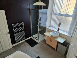 een badkamer met een douche, een toilet en een wastafel bij 2 Mill Street in Penrith +16 foto's