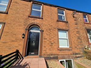 a brick building with a black door on it at 2 Mill Street in Penrith