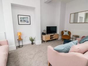 ein Wohnzimmer mit zwei Sofas und einem Fernseher in der Unterkunft 1 Princess Street in Scarborough