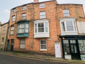 ein rotes Backsteingebäude mit einer weißen Tür auf einer Straße in der Unterkunft 1 Princess Street in Scarborough