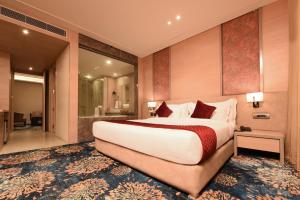 a hotel room with a large bed and a bathroom at The Pribson Hotel in Amritsar