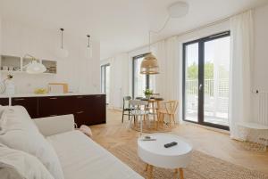 a white living room with a white couch and a table at LoveSea apartments Rewal in Rewal