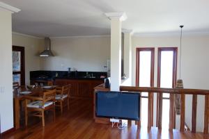 ein Wohnzimmer mit einem TV und einem Tisch mit Stühlen in der Unterkunft Villa met zeezicht / nieuwstaat / gratis parkeren in Porto Seguro