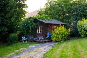 una pequeña casa con un banco y sillas en el patio en Stanica pod Zadzierną Kemping Domki letniskowe, en Lubawka 72 fotos más
