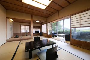 a living room with a table and a large window at Mizuno Ryokan in Karatsu