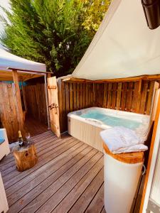 eine Whirlpool-Badewanne auf einer Holzterrasse in der Unterkunft CASA da CARMEN - Relax & Tradizione in Mezzolombardo