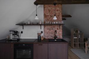 a kitchen with a sink and a brick wall at Österlen loft in Tomelilla