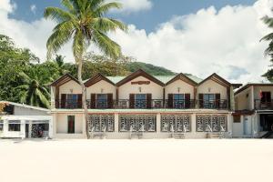 a building with a palm tree in front of it at Clef des Iles in Beau Vallon
