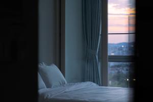 Bett in einem Zimmer mit Fenster in der Unterkunft Urbanstay Dongtan in Hwaseong