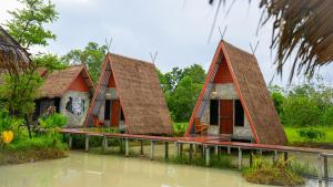 une maison au milieu d'une masse d'eau dans l'établissement Rice Wonder Cafe & Eco Resort, à Rayong