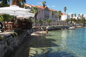 a person standing in the water at a resort at Double Room Korcula 4356c in Korčula