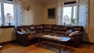 - un canapé en cuir brun dans un salon avec une table dans l'établissement Vegby Bolsgård "Annexet", à Moheda
