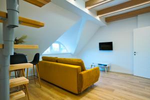 a living room with a yellow couch and a table at Cosy Studio in the City center with Air conditioneer! in Klaipėda