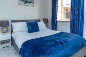 een slaapkamer met een bed met blauwe gordijnen en een raam bij Stunning 3-Bed Risa House in Beeston Nottingham in Nottingham