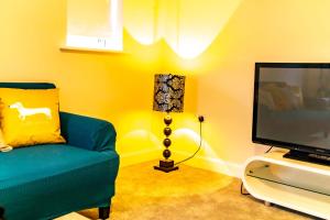 諾丁漢的住宿－Stunning 3-Bed Risa House in Beeston Nottingham，客厅配有蓝色的沙发和电视