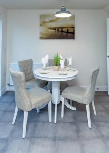 諾丁漢的住宿－Stunning 3-Bed Risa House in Beeston Nottingham，白色的餐桌、椅子和绘画
