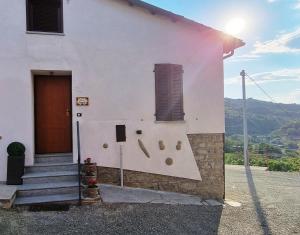 a white building with a door and a window at Ca ed Giuanoto in Santo Stefano Belbo