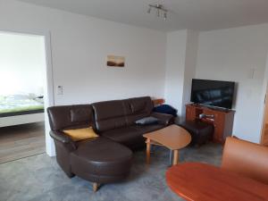 a living room with a couch and a television at Ferienwohnungen Donaumoos in Günzburg