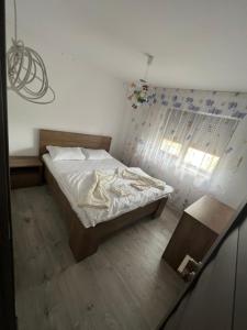 a small bedroom with a bed and a window at Apartament 5ive in Tăşnad