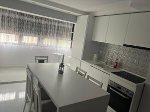 a kitchen with white cabinets and a white counter top at Apartament 5ive in Tăşnad