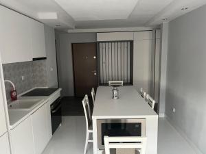 a kitchen with a table and chairs and a sink at Apartament 5ive in Tăşnad +3 photos