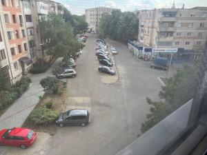 a street with cars parked in a parking lot at Apartament 5ive in Tăşnad