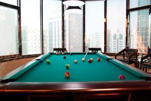 a pool table with balls on it in a room with windows at Al Diar Dana Hotel in Abu Dhabi