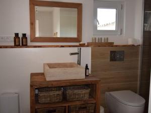 ein Badezimmer mit einem Waschbecken, einem Spiegel und einem WC in der Unterkunft Ferienhaus Galerie No 5 in Garding