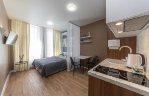 um quarto com uma cama e uma cozinha com um lavatório em MYFREEDOM Апартаменти метро Нивки em Kiev