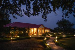 un edificio con luces en un jardín por la noche en Sariska Safari Lodge en Thāna Ghāzi