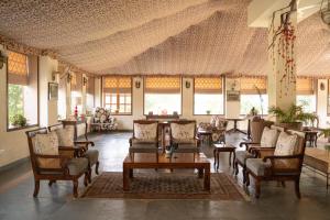 a lobby with couches and a table and chairs at Sariska Safari Lodge in Thāna Ghāzi