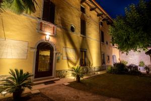 un gran edificio amarillo con puerta y patio en Casa Pellis, en Fagagna