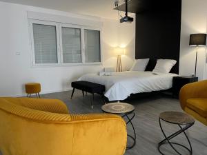 a hotel room with a bed and a couch at NG SuiteHome - Queven - Balnéo - Netflix - Wifi in Quéven