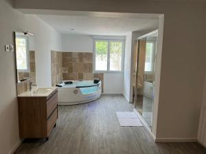 a bathroom with a tub and a sink and a bath tub at NG SuiteHome - Queven - Balnéo - Netflix - Wifi in Quéven