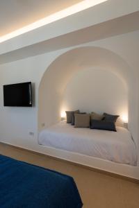 a bedroom with a bed with a tv on the wall at KAMEO, Antiparos in Antiparos