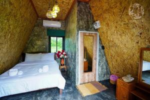 Rice Wonder Cafe & Eco Resort في رايونغ: غرفة نوم بسرير ومرآة في الغرفة
