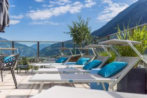 MANNI das Hotel في مايرهوفن: صف من الطاولات والكراسي مع الجبال في الخلفية