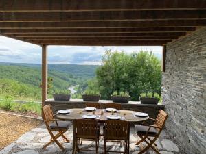a table and chairs on a patio with a view at Castorama in Rochehaut