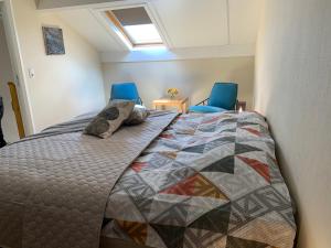 1 dormitorio con 1 cama y 2 sillas azules en Castorama, en Rochehaut